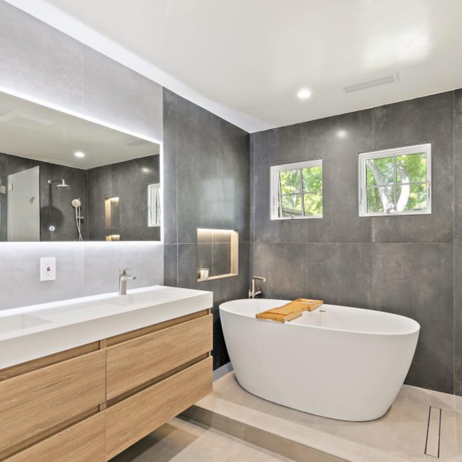 bathroom remodel showcasing new floating wooden vanity and white porcelain free-standing tub