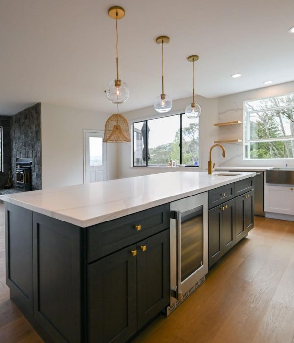 473668341_122166311312278422_8961995104713120197_n Empty fully remodeled kitchen with a luxurious dark-colored central island and hard-wood floors